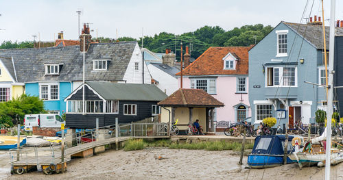 Houses by buildings in town against sky