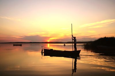 Silhouette boat in sea against sky during sunset