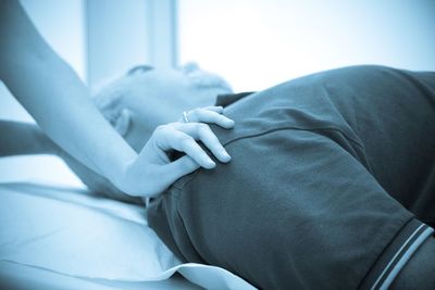 Close-up of hands on bed