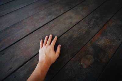 High angle view of person hand on floorboard