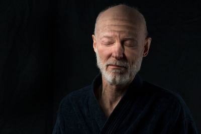 Portrait of mature man against black background