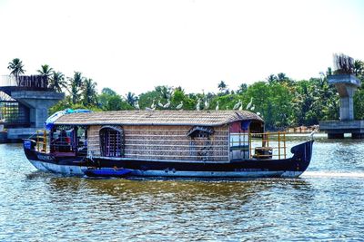 Boat sailing in river against clear sky