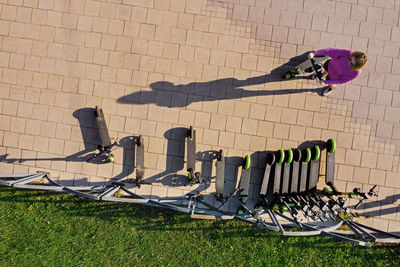 Woman with electric push scooter on footpath at park