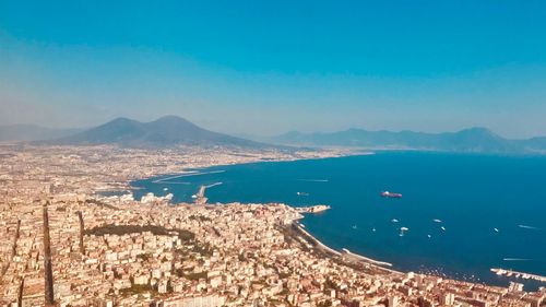 High angle view of sea and cityscape against sky