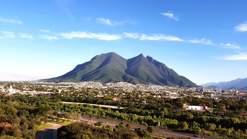 Scenic view of townscape and mountains against sky