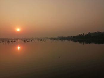 Scenic view of lake against orange sky