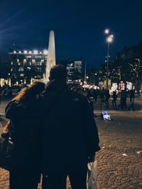 Rear view of woman on illuminated city at night