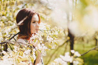 Portrait of woman by flowering tree