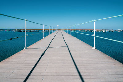 View of bridge over sea against clear blue sky
