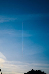 Vapor trail against blue sky