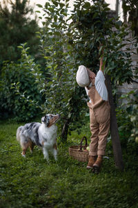 Man with dog standing in yard