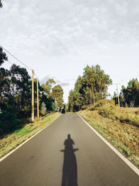 Shadow of man on road against sky