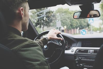 Rear view of man driving car