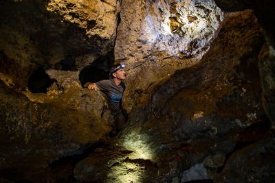 Mature man looking at rocks in cave