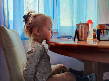 Side view of woman using mobile phone at home