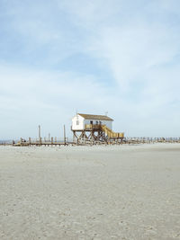 Lifeguard hut on beach against sky