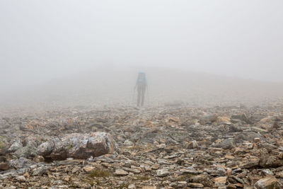 Hiker on field during foggy weather