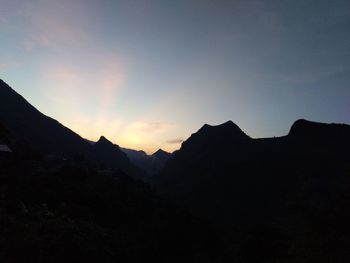 Scenic view of silhouette mountains against sky at sunset
