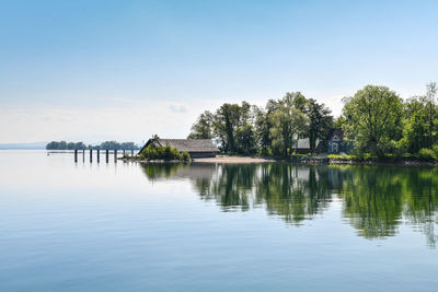 Scenic view of lake by trees against sky