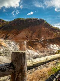 Wooden fence on mountain against sky