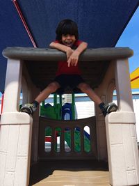 Low angle view of boy playing at playground