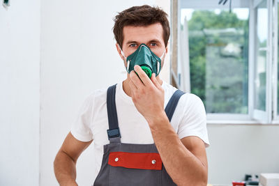 Portrait of man standing against white wall