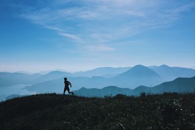 Silhouette man on mountain against sky
