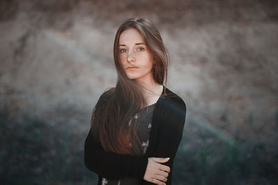 Portrait of woman standing against wall