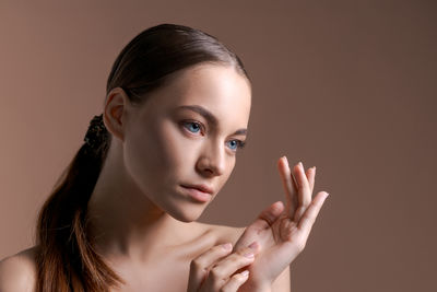 Portrait of young woman against white background