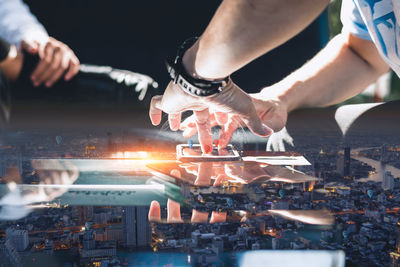 Cropped image of man holding illuminated string lights