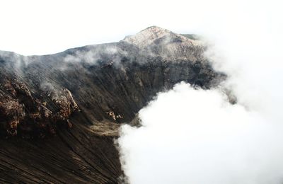 Smoke emitting from volcanic mountain against sky