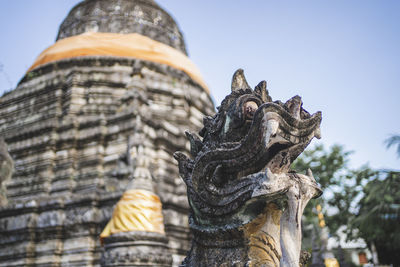 Low angle view of statue against temple building against sky