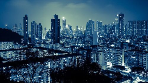 Illuminated cityscape against sky at night