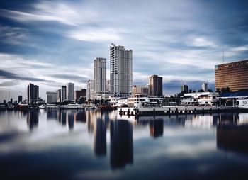 Reflection of buildings in city against sky