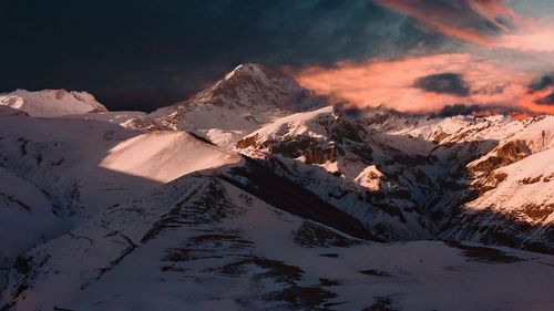 Scenic view of snowcapped mountains against sky during sunset