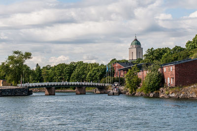 River by temple against sky in city