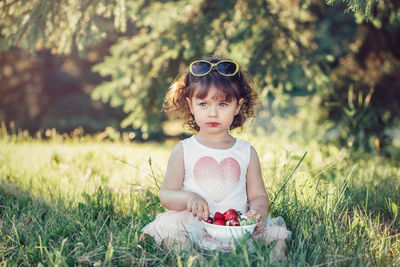 Cute girl siting on grass at park