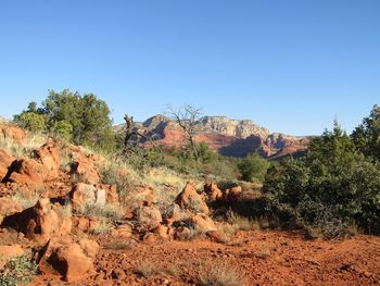 Rocks on land against clear blue sky