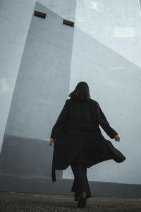 Rear view of woman walking on footpath