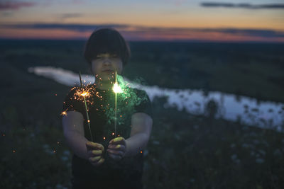 Young woman holding illuminated string lights