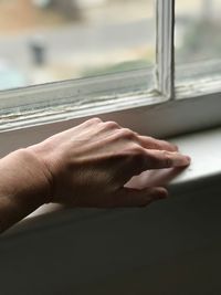 Cropped hand on window sill