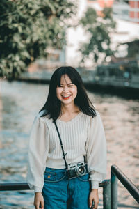 Portrait of smiling young woman standing outdoors