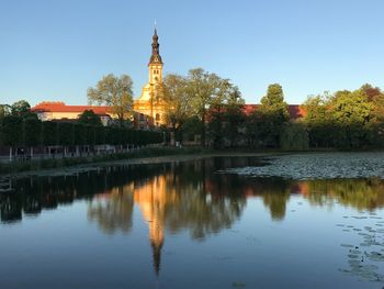 Reflection of trees in lake at sunset