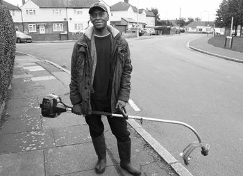 Portrait of young man standing on road