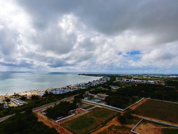 High angle view of cityscape by sea against sky