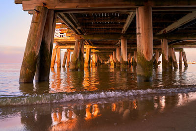 Reflection of pier on sea against sky