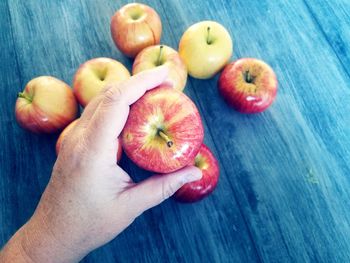 High angle view of man holding apple on table