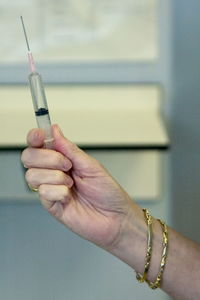 Cropped hand of woman holding syringe