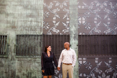 Friends standing against wall