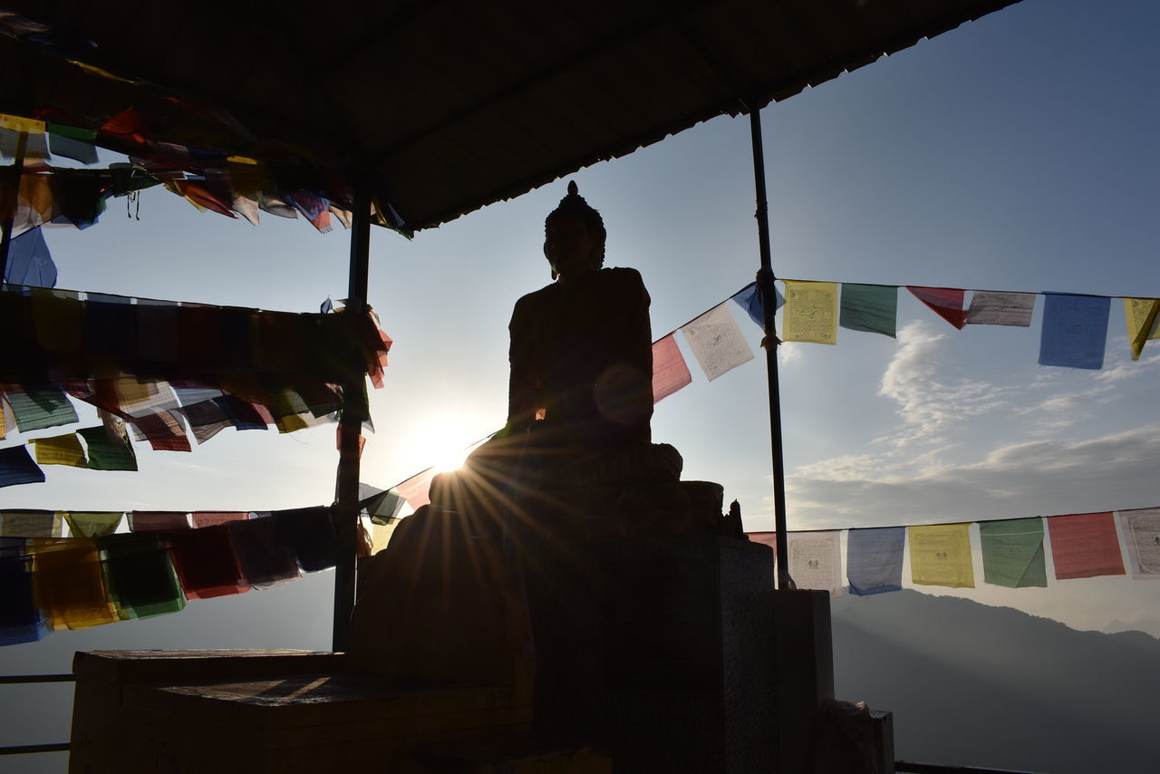 LOW ANGLE VIEW OF MAN RELAXING AT TEMPLE